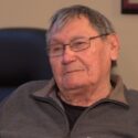 A photo of an Tom Daniels, one of the ironworkers featured in Alvin Finkel's story Waltzing with the Angels. Here he is an older man with glasses, sitting in an office.