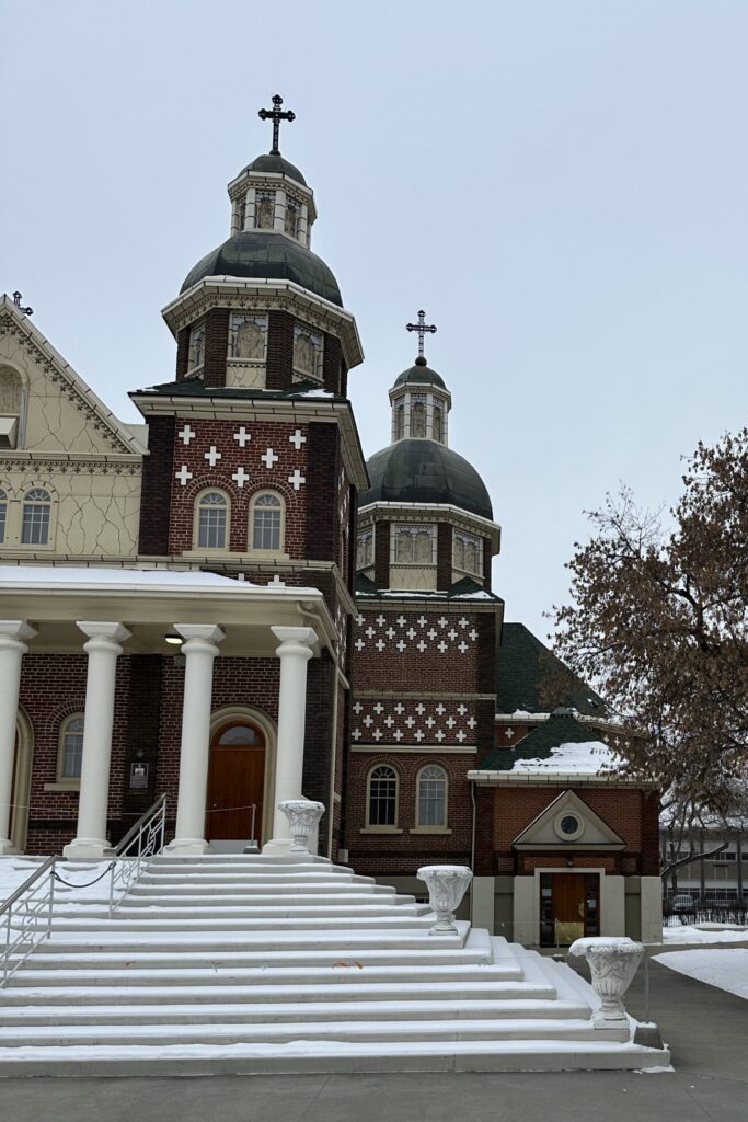 A photo of two decorated spires on a cathedral in winter.